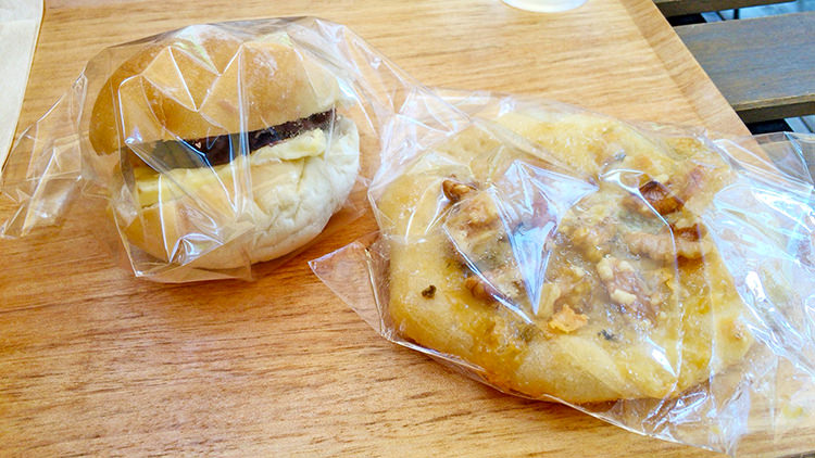 パンとcafé えだおねの人気商品のあんバター（写真左）、蜂蜜の甘さとチーズ・クルミの塩気が絶妙のタルトフランベ（写真右）