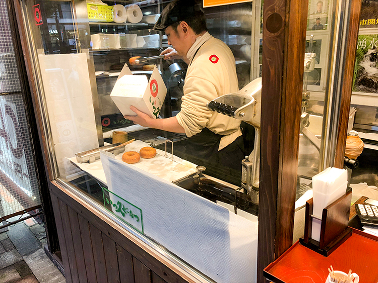 いっ久どーなつの店員さんがドーナツを詰める様子