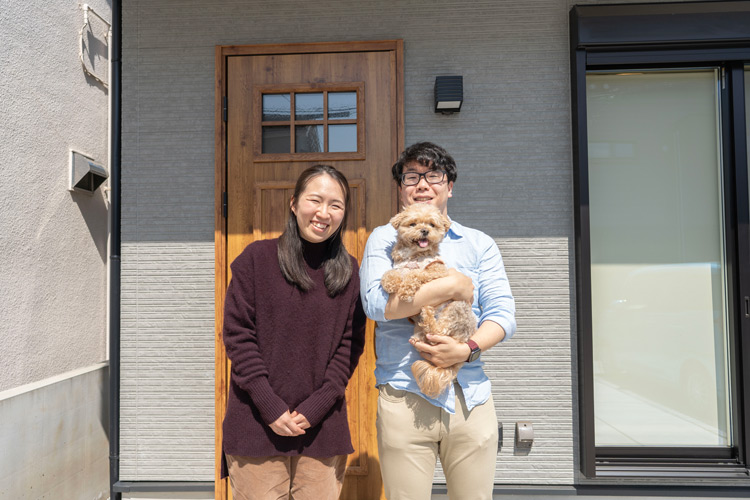 新居の玄関前で微笑むご夫婦