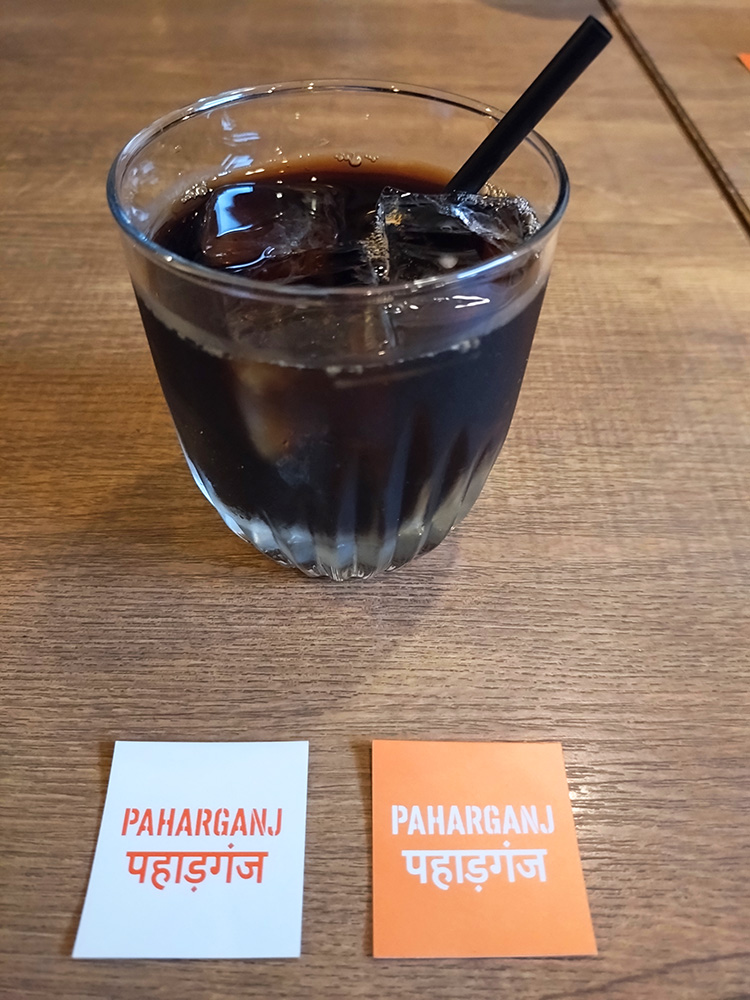 「スパイスバル パハルガンジ」のアイスコーヒーとロゴ
